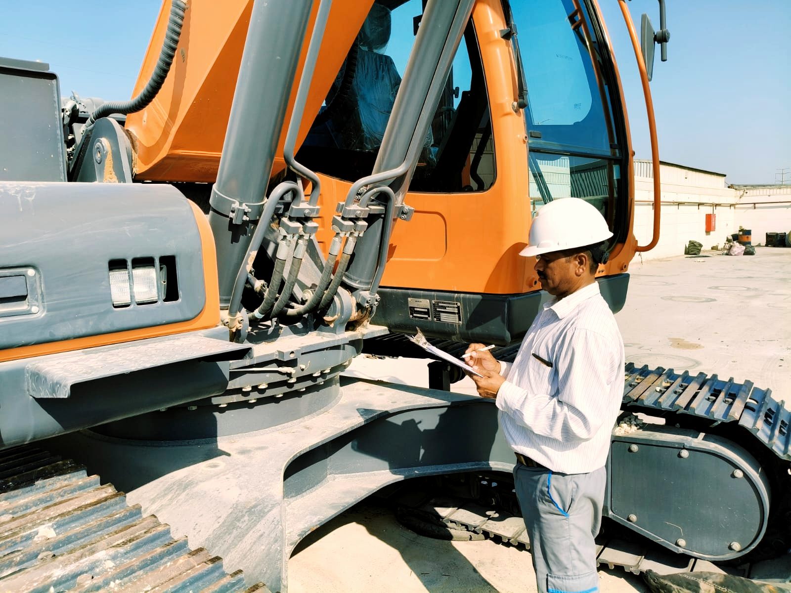 A RANCO supervisor inspecting a machine with a clipboard